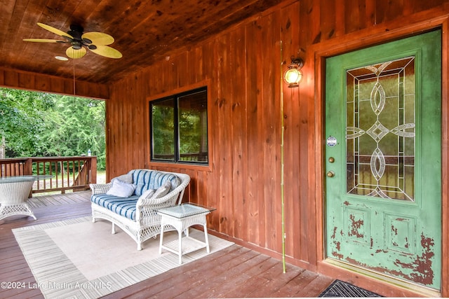 property entrance with ceiling fan, a deck, and an outdoor living space