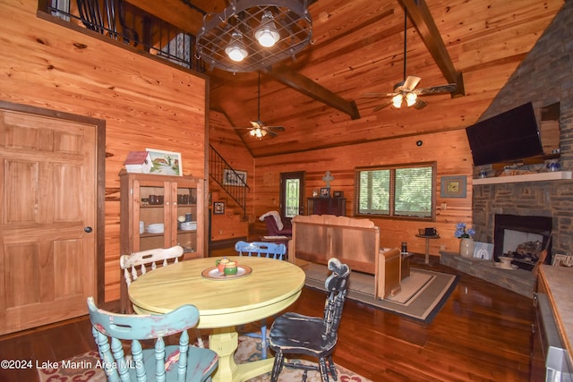 dining space with dark hardwood / wood-style floors, beam ceiling, a fireplace, and high vaulted ceiling