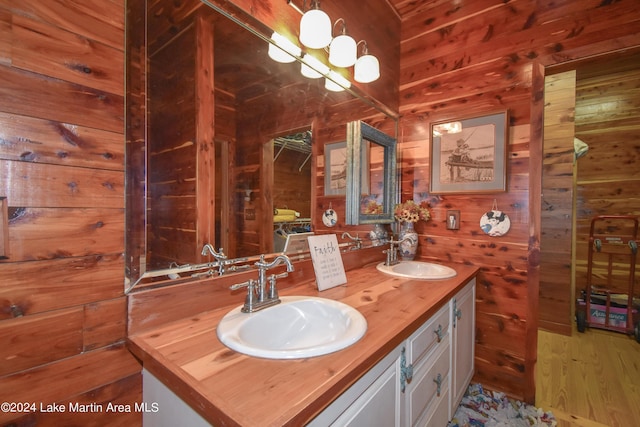 bathroom featuring hardwood / wood-style floors, vanity, and wooden walls