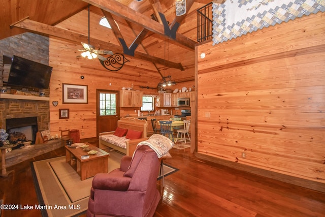 living room featuring beamed ceiling, hardwood / wood-style floors, high vaulted ceiling, and wooden walls