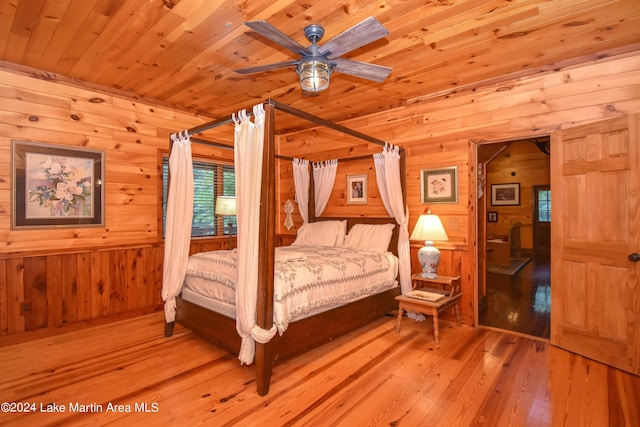 bedroom with wood ceiling, light hardwood / wood-style flooring, ceiling fan, and wood walls