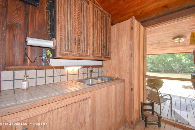 kitchen featuring tile countertops, tasteful backsplash, sink, and light hardwood / wood-style flooring