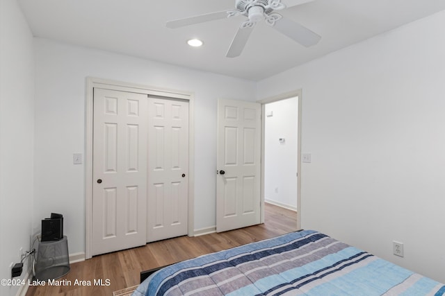 bedroom with ceiling fan, light hardwood / wood-style floors, and a closet