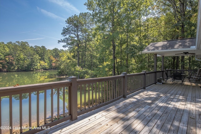 deck with a water view and ceiling fan