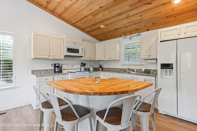 kitchen with lofted ceiling, sink, light hardwood / wood-style floors, and white appliances