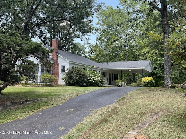 ranch-style home featuring a carport and a front yard