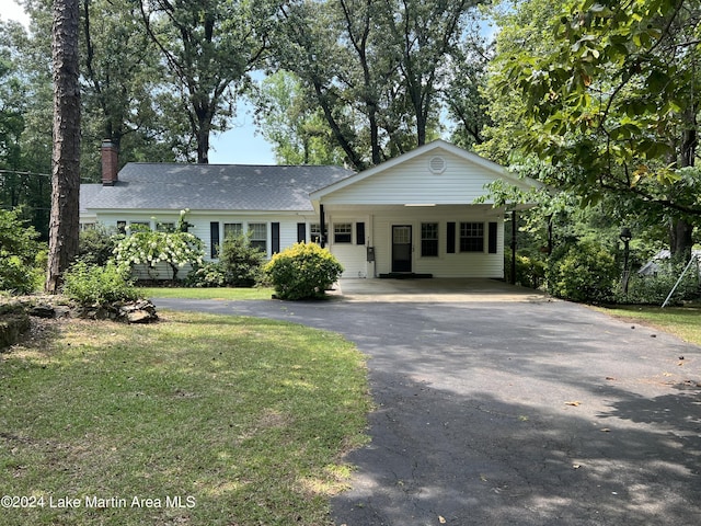 ranch-style house with a carport and a front lawn