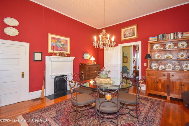 dining space featuring dark hardwood / wood-style flooring, an inviting chandelier, and ornamental molding