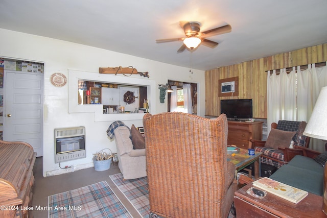 living room with heating unit, wood walls, ceiling fan, and concrete flooring