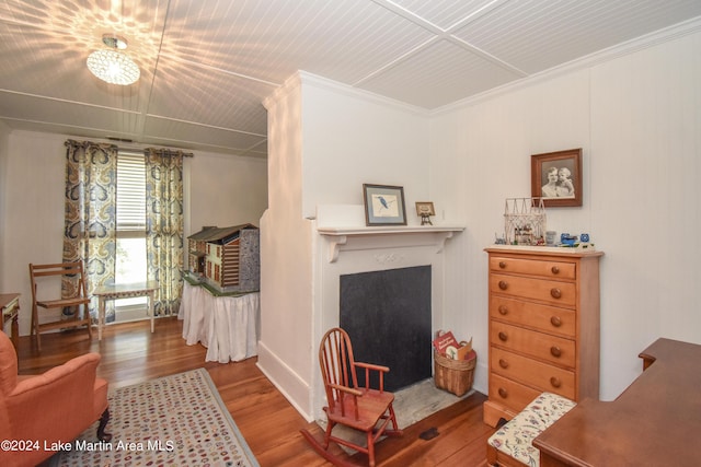 living area with hardwood / wood-style floors and ornamental molding