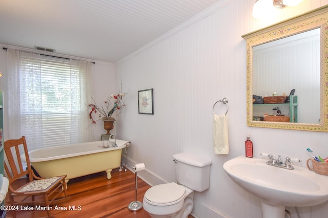 bathroom with hardwood / wood-style floors, a bathtub, crown molding, sink, and toilet