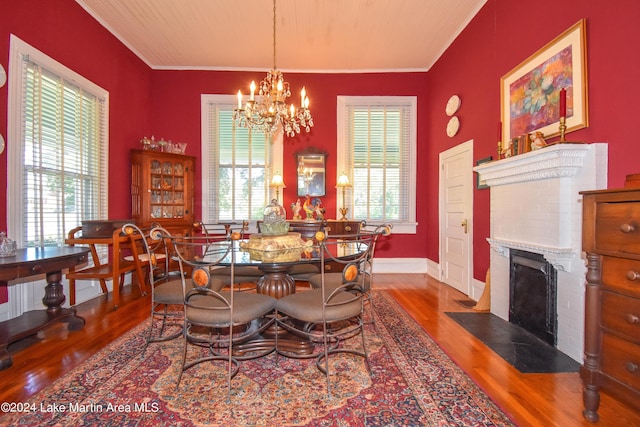 dining room with dark hardwood / wood-style flooring, a brick fireplace, a healthy amount of sunlight, and crown molding