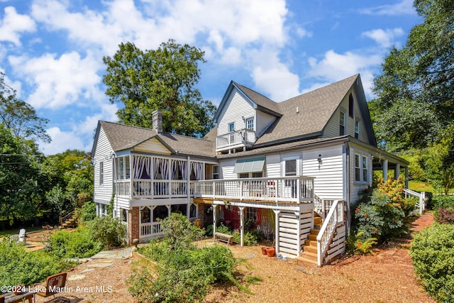 rear view of property featuring a wooden deck