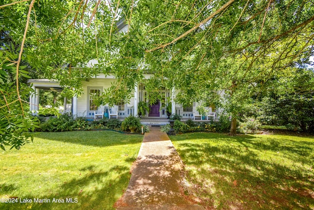 obstructed view of property with covered porch and a front yard