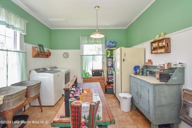 interior space featuring washing machine and clothes dryer, light tile patterned floors, and ornamental molding