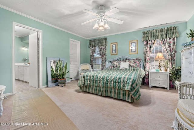 carpeted bedroom featuring ornamental molding, connected bathroom, a textured ceiling, and ceiling fan