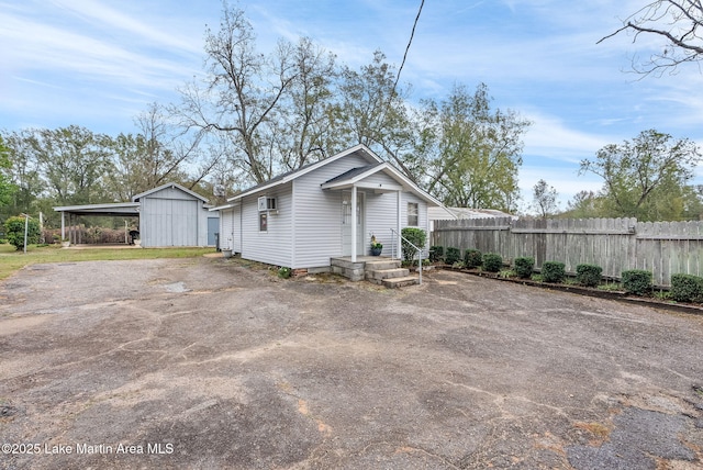 view of home's exterior featuring a carport and a storage unit