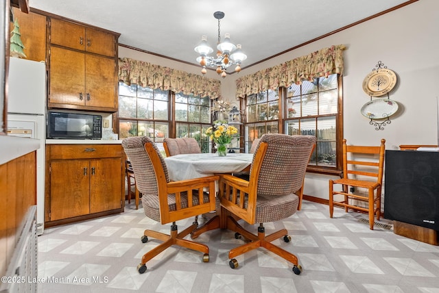 dining space featuring crown molding and a notable chandelier