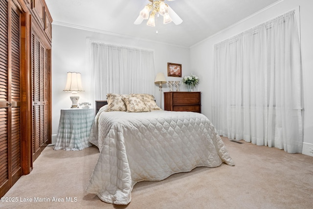 carpeted bedroom featuring ornamental molding and ceiling fan