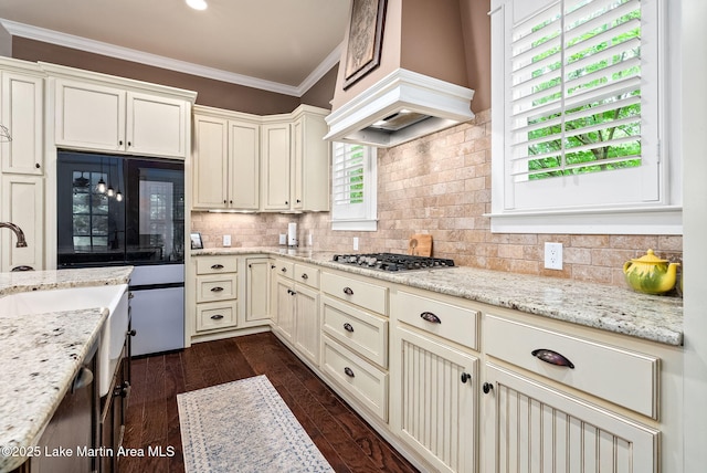 3408 Quail Cv, Opelika, AL 36801 - kitchen with stainless steel gas cooktop, ornamental molding, premium range hood, dark wood finished floors, and decorative backsplash