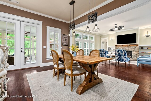 3408 Quail Cv, Opelika, AL 36801 - dining room with a stone fireplace, french doors, crown molding, dark wood-style flooring, and baseboards