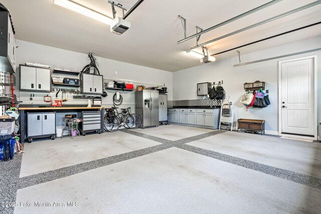 3408 Quail Cv, Opelika, AL 36801 - garage featuring a garage door opener, stainless steel fridge with ice dispenser, and electric panel
