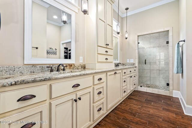 3408 Quail Cv, Opelika, AL 36801 - bathroom with crown molding, a shower stall, double vanity, wood finished floors, and baseboards