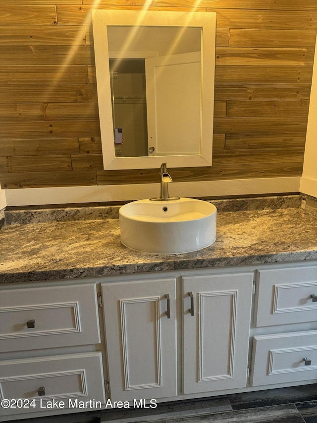 bathroom featuring wooden walls and vanity