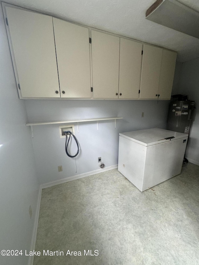 clothes washing area featuring electric dryer hookup, washer hookup, cabinet space, and baseboards