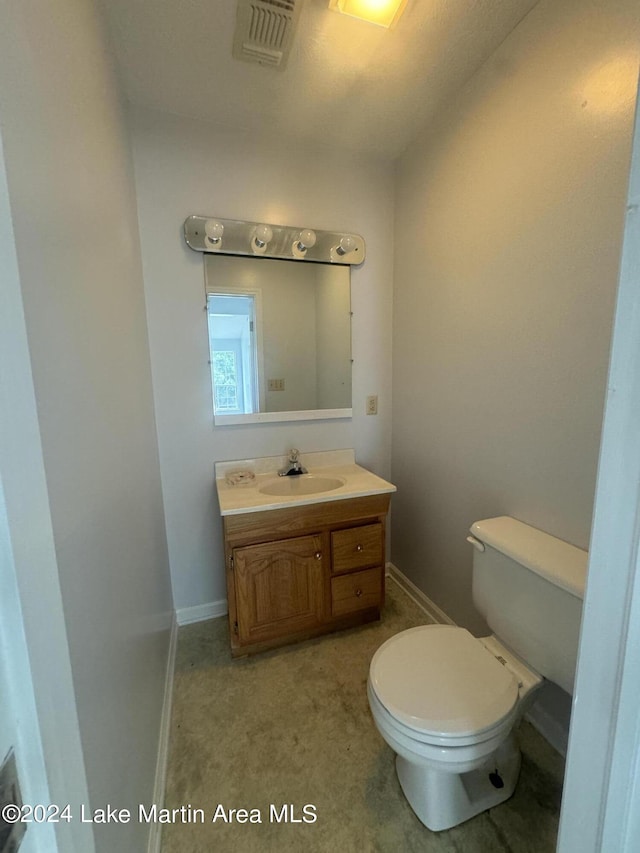 bathroom featuring toilet, visible vents, vanity, and baseboards