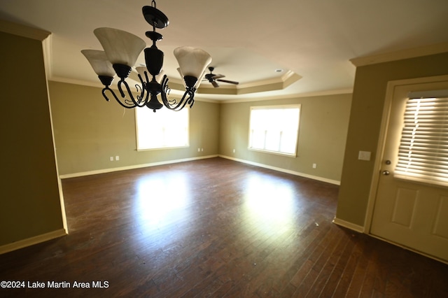 empty room featuring a raised ceiling, crown molding, ceiling fan with notable chandelier, and dark hardwood / wood-style floors