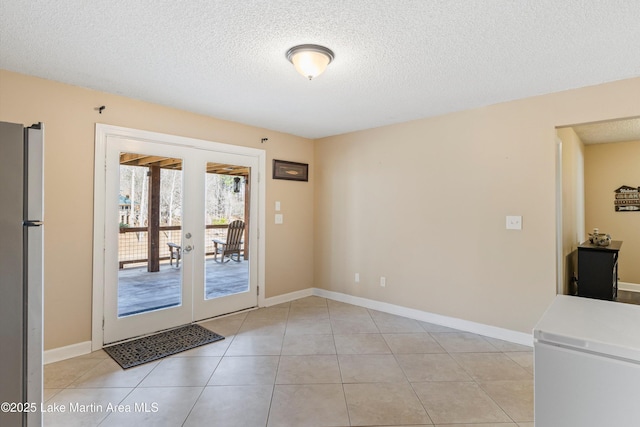 doorway to outside featuring light tile patterned floors, a textured ceiling, and french doors