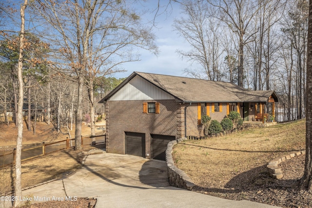 view of side of property featuring concrete driveway, fence, a porch, a garage, and brick siding
