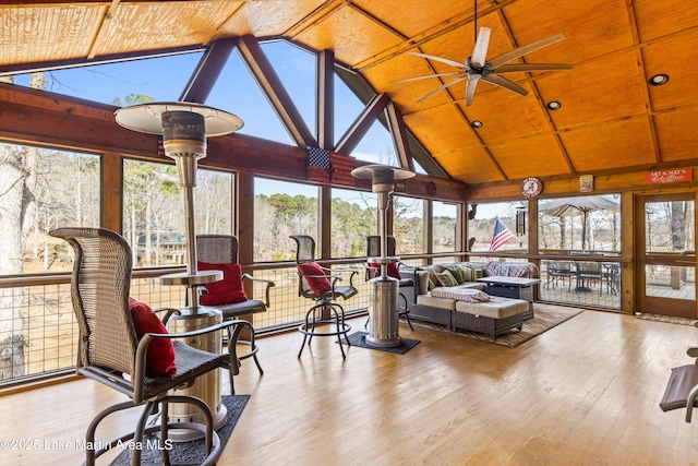 sunroom featuring vaulted ceiling, ceiling fan, and wood ceiling