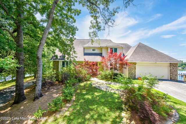 127 Ridge Crest Dr, Jacksons Gap, AL 36861 - view of front of house featuring a garage, stone siding, driveway, and a shingled roof