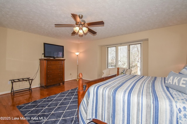 127 Ridge Crest Dr, Jacksons Gap, AL 36861 - bedroom featuring wood finished floors, a textured ceiling, baseboards, and a ceiling fan