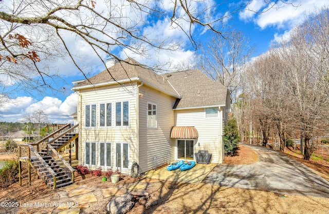 127 Ridge Crest Dr, Jacksons Gap, AL 36861 - rear view of house with roof with shingles, stairs, a chimney, and a patio area
