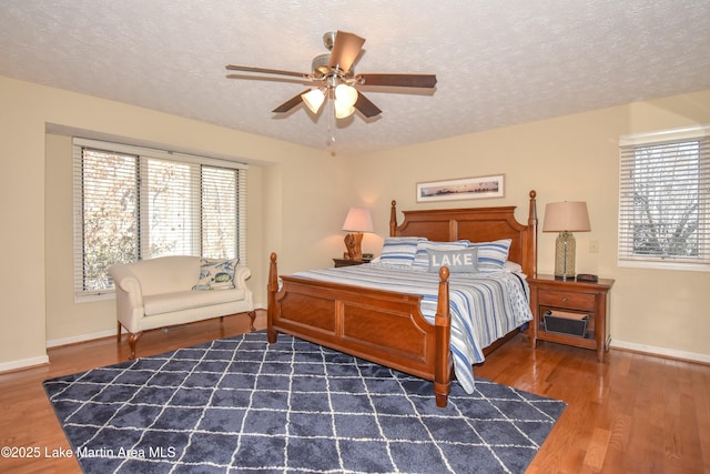127 Ridge Crest Dr, Jacksons Gap, AL 36861 - bedroom with multiple windows, wood finished floors, a textured ceiling, baseboards, and a ceiling fan