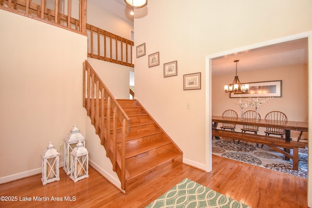 127 Ridge Crest Dr, Jacksons Gap, AL 36861 - stairs with wood finished floors, baseboards, a chandelier, and a towering ceiling
