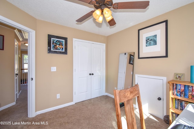 carpeted bedroom featuring ceiling fan, a closet, and a textured ceiling