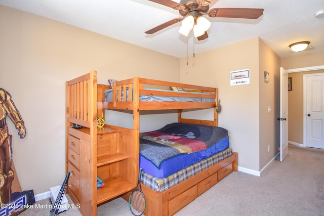 bedroom featuring ceiling fan, light colored carpet, and a textured ceiling