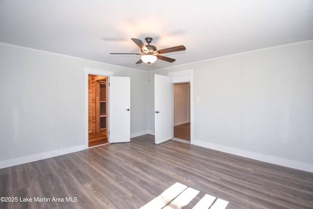 unfurnished bedroom with ceiling fan, dark wood-type flooring, and ornamental molding