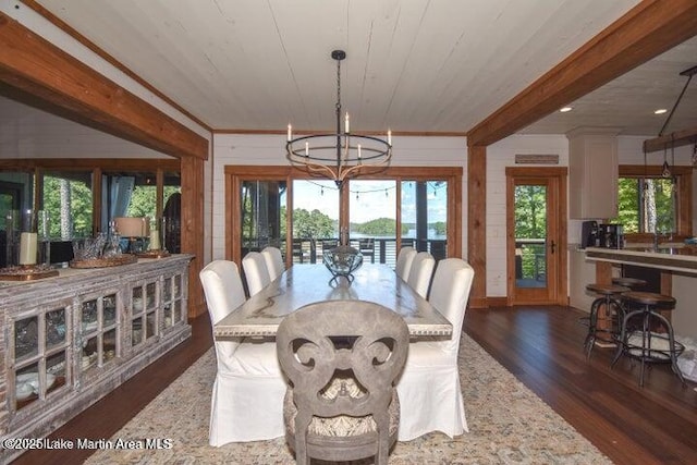 dining space featuring dark wood-type flooring, wooden walls, wood ceiling, and a chandelier