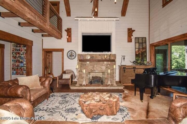 living room with beamed ceiling and a high ceiling