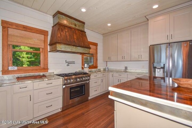 kitchen featuring dark wood-type flooring, custom exhaust hood, wooden ceiling, stainless steel appliances, and white cabinets