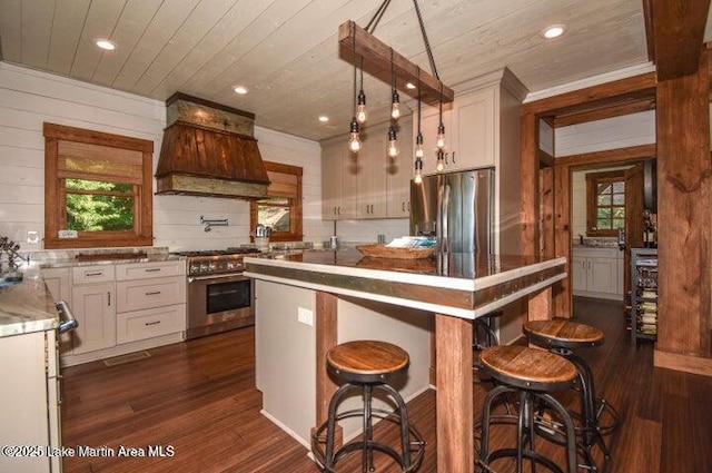 kitchen featuring white cabinetry, a kitchen island, custom range hood, and appliances with stainless steel finishes