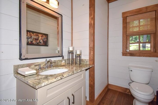 bathroom featuring vanity, wood-type flooring, and toilet