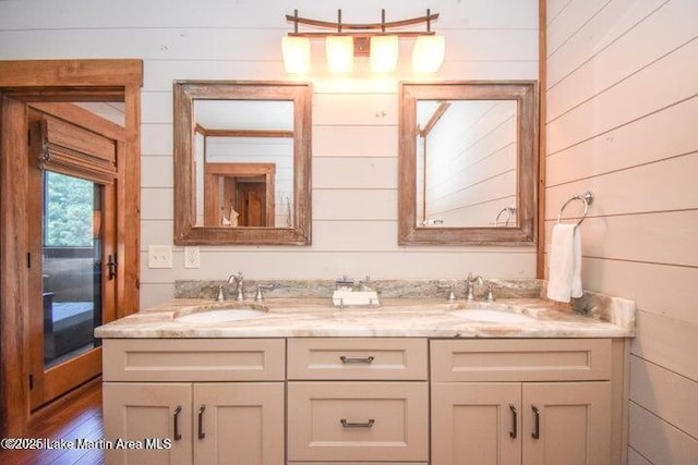 bathroom with hardwood / wood-style flooring, vanity, and wooden walls