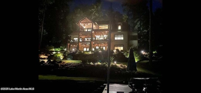 back house at twilight with a balcony