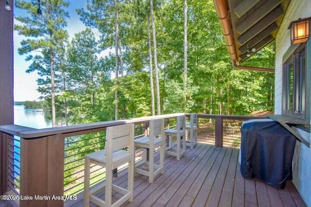 wooden deck with a water view and grilling area